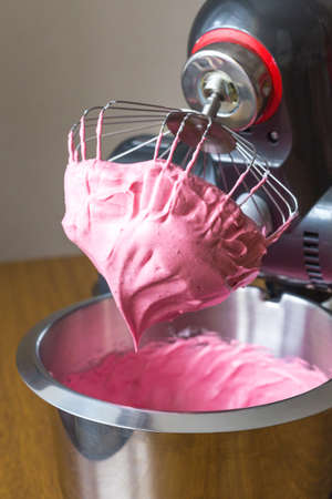 Mixed eggs and berry syrop in food processor and beater on the table closeupの写真素材