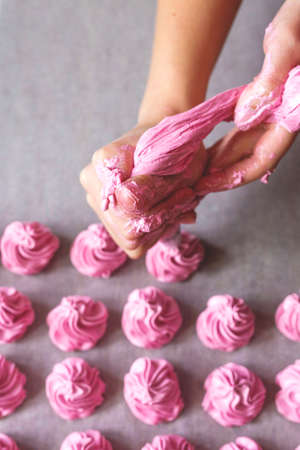 Raws of homemade strawberry marshmallow dessert making with cream injector. Fabrication process.の写真素材