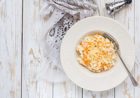 Stortini Vegetarian Vegetable pasta with carrot, cheese and ricotta in white bowl on wooden table. Top viewの写真素材