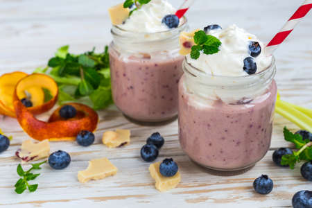 Blueberry and blood orange fruit smoothie with celery, whipped cream and white chocolate. Milk shake in glass jar. Yogurt cocktail. Concept of healthy food. Natural detoxの写真素材