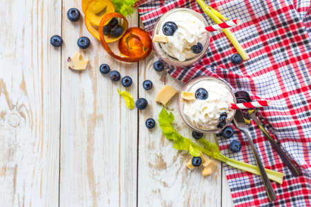 Blueberry and blood orange fruit smoothie with celery, whipped cream and white chocolate. Milk shake in glass jar. Yogurt cocktail. Concept of healthy food. Natural detoxの写真素材