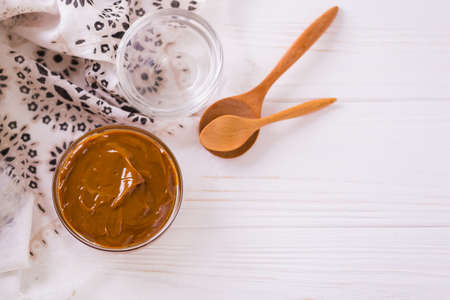 Bowl of homemade melted caramel sauce on wooden backgroungの写真素材