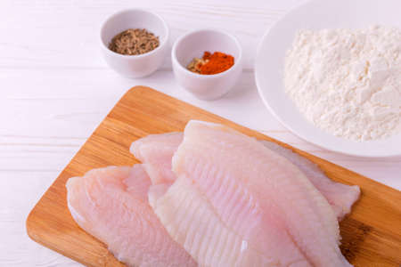 Ingridients for cooking crispy fried fish tilapia. Raw fillet, fleur, cumin and spices. Healthy food conceptの写真素材