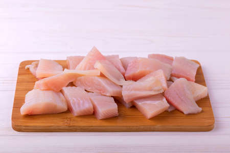 Ingridients for cooking crispy fried fish tilapia. Chopped raw fillet on cutting board. Healthy food conceptの写真素材