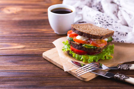 Rye bread sandwich with cherry tomatoes, cucumber, bell pepper, boiled egg and lettuce and espresso coffee for breakfast. Selective focusの写真素材