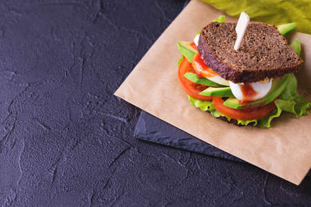 Rye bread sandwich with cherry tomatoes, lettuce green salad, avocado, boiled egg and tomato sauce for breakfast. Selective focusの写真素材
