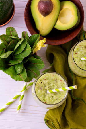 Green smoothie with avocado, spinach and celery in a mason jar on rustic wooden background. Healthy food and dieting conceptの写真素材