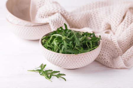 Fresh green arugula in bowl on wooden table. Healthy food and vegetarian conceptの写真素材