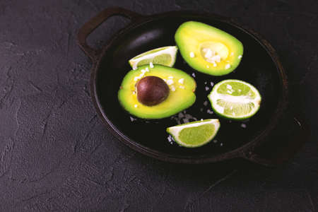 Avocado, sea salt and lime slices on stone background. Healthy food conceptの写真素材