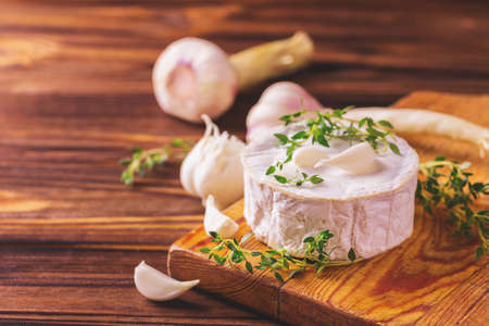 Traditional French homemade Camembert cheese with thyme and garlic. European cuisine. Selective focus.の写真素材