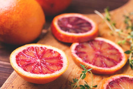 Citrus fruit background with sliced red bloody oranges and thyme. Healthy food concept. Natural vitamins.の写真素材