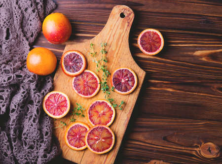 Citrus fruit background with sliced red bloody oranges and thyme. Healthy food concept. Natural vitamins.の写真素材