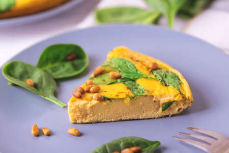 Hot homemade frittata with eggs, spinach, cheese and pine nuts in iron pan. on wooden table.Traditional Italian cuisine, healthy food concept.の写真素材