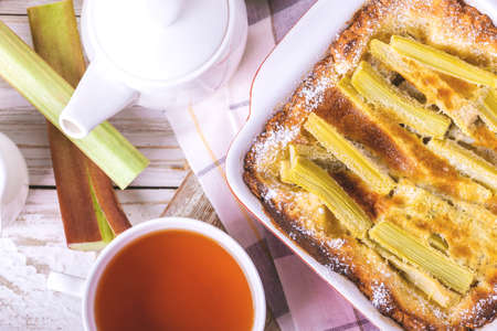 Traditional rhubarb pie with tea for breakfast. Sweet pieplant cake baked pastry food on rustic wooden table backgroundの写真素材