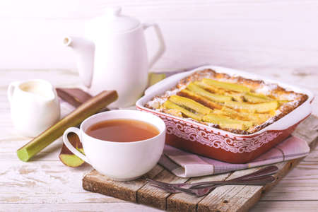 Traditional rhubarb pie with tea for breakfast. Sweet pieplant cake baked pastry food on rustic wooden table backgroundの写真素材