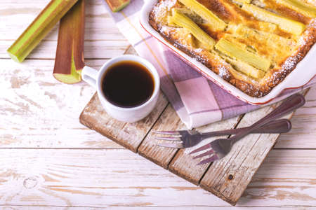 Traditional rhubarb pie with espresso coffee for breakfast. Sweet pieplant cake baked pastry food on rustic wooden table backgroundの写真素材