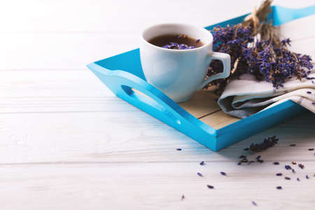 Cup of coffee with lavender flowers on white wooden table. Lifestyle concept. Selective focusの写真素材