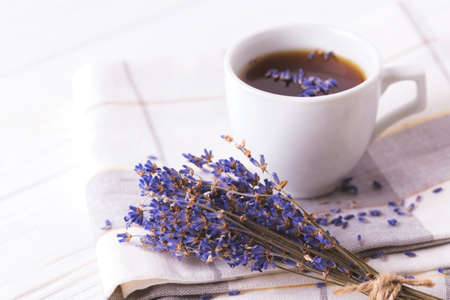 Cup of coffee with lavender flowers on white wooden table. Lifestyle concept. Selective focusの写真素材