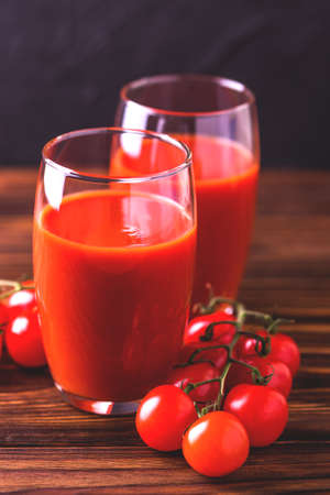 Glasses of tomato juice with sea salt and celery on wooden background. Healthy food concept.の写真素材