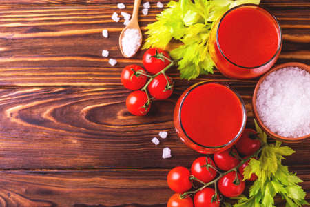 Glasses of tomato juice with sea salt and celery on wooden background. Healthy food concept.の写真素材