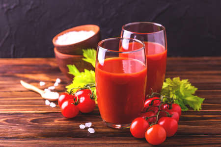 Glasses of tomato juice with sea salt and celery on wooden background. Healthy food concept.の写真素材