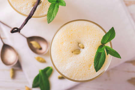 Traditional Indian mango lassi curd with cardamon, mint, vanilla and saffron served in terracotta glasses. Kesariya. Keshariya. Kesar. Yogurt smoothieの写真素材