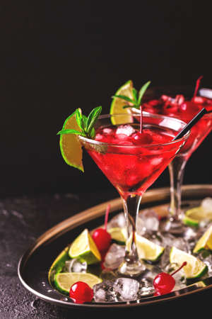 Strawberry daiquiri cocktail with lime, strawberry syrop, cherry and mint on black background. Summer drink, refreshment, Aperitif. Selective focusの写真素材