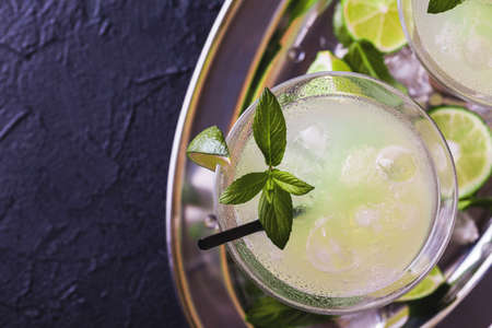 Classic daiquiri cocktail with lime, ice and mint on black background. Summer drink, refreshment, Aperitif. Selective focusの写真素材
