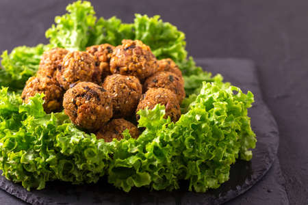 Traditional homemade falafel served with salad and pita on black stone table. Jewish Cuisine. Horizontal viewの写真素材