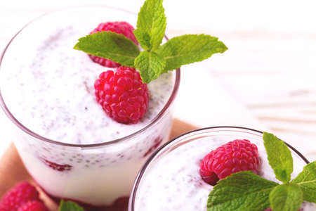 Raspberries chia pudding and fruit smoothie with mint or milk shake in glass jar with wooden background. Yogurt cocktail. Close up. Concept of healthy food and Superfoods. Natural detoxの写真素材