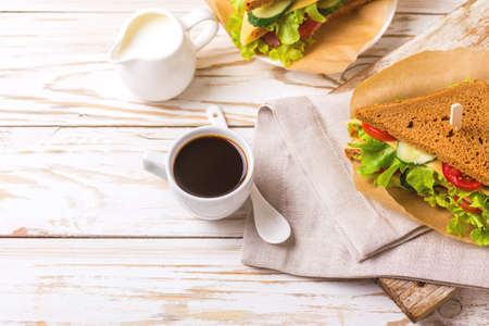 Rye bread sandwich with ham, cheese, cherry tomatoes, cucumber and lettuce and espresso coffee for breakfast. Selective focusの写真素材