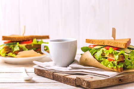 Rye bread sandwich with ham, cheese, cherry tomatoes, cucumber and lettuce and espresso coffee for breakfast. Selective focusの写真素材