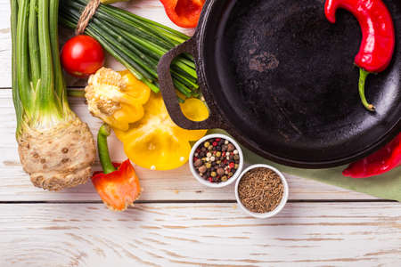 Various vegetables ingredients on wooden table around frying pan for tasty diet. Top view. Food cooking ackground with copy space.の写真素材