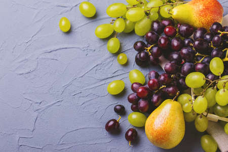 Fresh grapes and pears on gray stone background. Copyspace. Horizontal Viewの写真素材