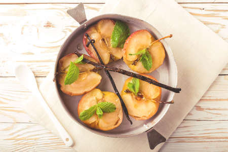 Homemade baked red apples with vanilla syrop, mint and honey. Close up. Top viewの写真素材