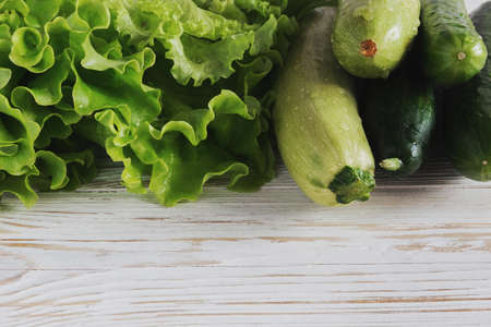 Zucchini, squash, cucumbers and salad on white rustic wooden backgroundの写真素材