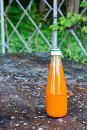 Bottled carrot juice on wooden backgroundの写真素材