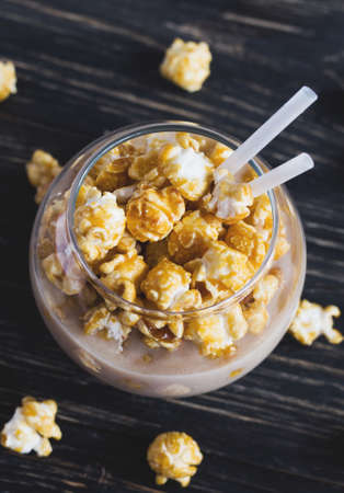 Cup of cacao with caramel popcorn on wooden tableの写真素材