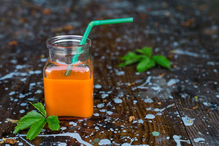 Bottled carrot juice on wooden backgroundの写真素材