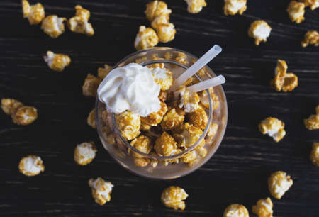 Cup of cacao with caramel popcorn and Whipped Cream on wooden tableの写真素材