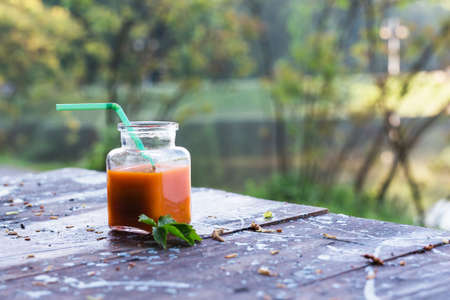 Bottled carrot juice on wooden backgroundの写真素材
