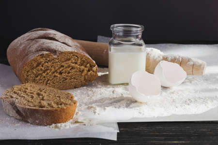 Whole wheat homemade bread, bio ingredients, healthy food. Milk, meal and eggs around.の写真素材
