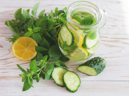 Homemade lemonade with fresh lemon, cucumbers and mint on white wooden background.の写真素材