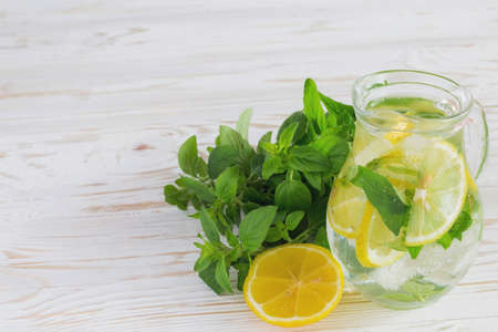 Homemade lemonade with fresh lemon and mint on white wooden background.の写真素材