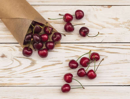 Ripe red cherries closeup on a white wooden backgroundの写真素材