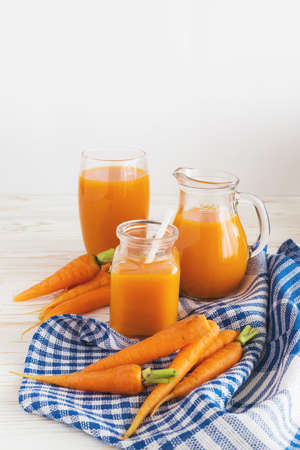 Fresh-squeezed carrot juice and carrots on wooden backgroundの写真素材