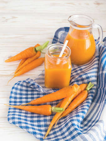 Fresh-squeezed carrot juice and carrots on wooden backgroundの写真素材