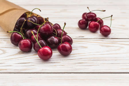Ripe red cherries closeup on a white wooden backgroundの写真素材