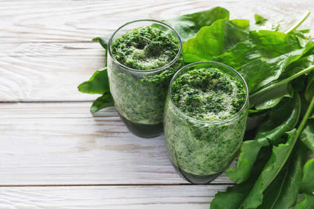 Healthy green sorrel and spinach smoothie in glass jar with wooden background.の写真素材