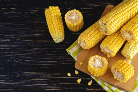 Fresh sweet corn on cobs at black rustic wooden tableの写真素材